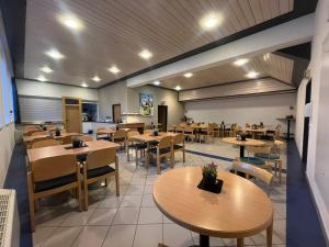 a restaurant with tables and chairs in a room at Twenty Seven Budget Hotel in Zell am See