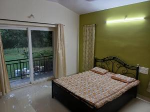 阿里巴格的住宿－Anushashi's Homestay，一间卧室设有一张床和一个大窗户
