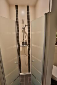 a shower in a bathroom with a glass door at Vakantiewoning Casa Maran in een groene omgeving te Heusden-Zolder in Heusden - Zolder