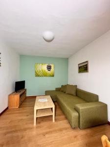 a living room with a green couch and a table at Vila Morava in Liptovský Mikuláš