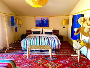 a bedroom with a bed and a rug at Pueblo Touareg - Private Tents in Merzouga