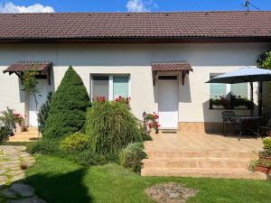 a house with a patio and an umbrella at Privát Pekný dvor in Rajecké Teplice