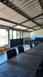 a room with a long table and chairs and windows at La Quinta de LOS ABU in Ramallo