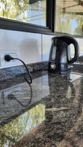 a tea kettle sitting on a counter next to a window at Casa Quinta in Ramallo