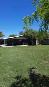 a large building with a grass field in front of it at Casa Quinta in Ramallo