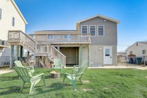 a house with two green chairs in the yard at Mystic Island Bay Breeze in Little Egg Harbor Township