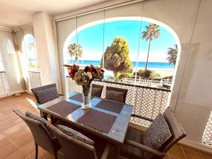 a dining room with a table and a view of the beach at 111 marina duquesa in Manilva