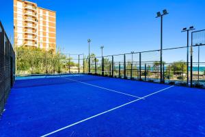 a tennis court in front of a building at 111 marina duquesa in Manilva