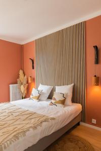 een slaapkamer met een groot bed met oranje muren bij Hypercentre le chaleureux appart in Troyes