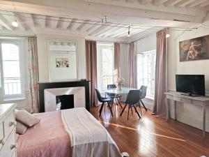 - une chambre avec un lit et une table avec des chaises dans l'établissement Villa Republique Normandie Liberté, à Caen