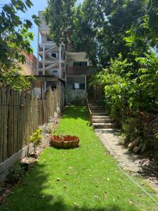 um quintal em frente a uma casa com uma cerca em Pituba Ville - Ap - 1 andar - 2/4 em Itacaré