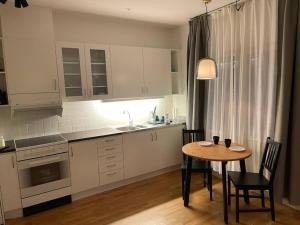 uma cozinha com uma mesa e cadeiras e um lavatório em Mysig lägenhet i City em Norrköping