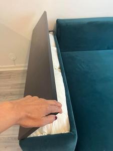 uma mão está segurando uma pasta em uma cama em Mysig lägenhet i City em Norrköping