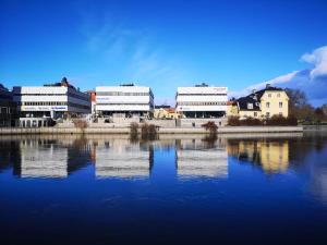 un grupo de edificios sentados junto a una masa de agua en Mysig lägenhet i City, en Norrköping