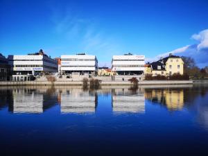 a group of buildings sitting next to a body of water at Mysig lägenhet i City in Norrköping
