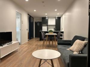 een woonkamer met een bank en een tafel bij Top Floor Vincent in Auckland