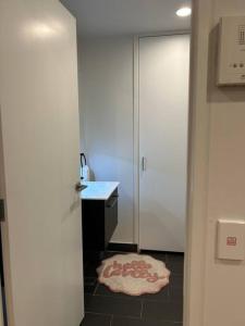 een badkamer met een witte deur en een tapijt op de vloer bij Top Floor Vincent in Auckland