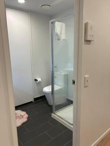 een badkamer met een glazen douche en een toilet bij Top Floor Vincent in Auckland