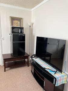 1 dormitorio con 1 cama, TV y mesa en Executive Room, en North Fort Myers