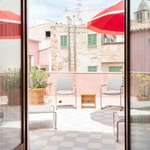 a patio with two chairs and an umbrella at Palau Sa Font in Palma de Mallorca