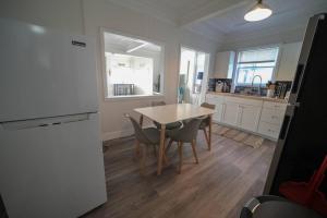 cocina con mesa, sillas y nevera en The Historic Oneida Lake House - Condo 3, en Blossvale