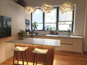 een keuken met een aanrecht met 2 krukken en een wastafel bij Loft del Talvera 2 in Bolzano +5 foto's