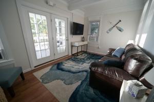 - un salon avec un canapé en cuir et un tapis dans l'établissement The Historic Oneida Lake House - Condo 4, à Blossvale