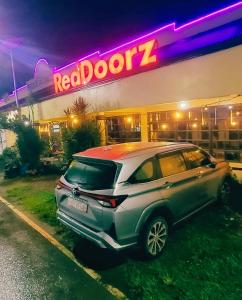 a car parked in front of a restaurant at night at San Juanico Travellers Inn - RedDoorz in Tacloban