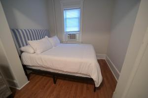 een klein bed in een kleine kamer met een raam bij The Historic Oneida Lake House - Condo 4 in Blossvale