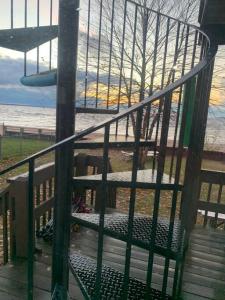 eine Bank auf einem Deck mit dem Ozean im Hintergrund in der Unterkunft The Historic Oneida Lake House Condo 5 (Penthouse) in Blossvale