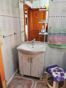 La salle de bains est pourvue d'un lavabo et d'un miroir. dans l'établissement Maison bord de mer, à Zaouia Sidi Ouaggag