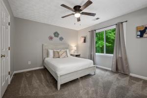 1 dormitorio con 1 cama y ventilador de techo en Relax In This 4BR Retreat With Screened Snug Porch, en Marietta