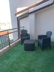 a balcony with two chairs and a table on a roof at B&B "LE LUCI" CAMERA IN ATTICO GRAN VISTA interno 4 in Vasto