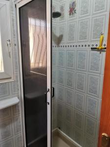 La salle de bains est pourvue d'une douche avec une porte en verre. dans l'établissement Maison bord de mer, à Zaouia Sidi Ouaggag