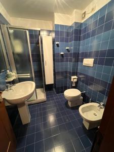 un bagno con due lavandini, un water e una doccia di Limone central suite Mountain View a Limone Piemonte