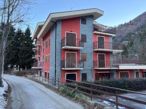 un edificio rojo al lado de una carretera en Limone central suite Mountain View, en Limone Piemonte