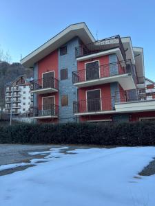 un edificio rosso con la neve davanti di Limone central suite Mountain View a Limone Piemonte