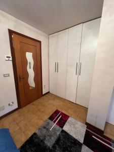 Habitación con armarios blancos y puerta marrón. en Limone central suite Mountain View, en Limone Piemonte