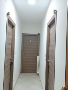 two brown doors in a hallway with white walls at B&B LE LUCI CAMERA IN ATTICO GRAN VISTA interno 4 rose bianche in Vasto +9 photos