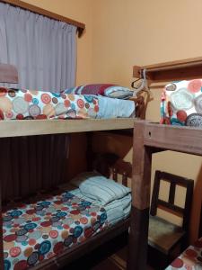 聖薩爾瓦多德胡胡伊的住宿－HOSTEL JUJUY，一间卧室配有两张双层床和椅子