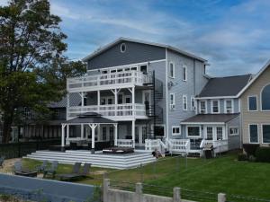 a large house with a porch and a deck at The Historic Oneida Lake House - Condo 2 in Blossvale