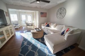a living room with a white couch and a television at The Historic Oneida Lake House - Condo 2 in Blossvale