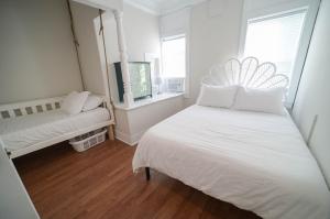 a white bedroom with a bed and a window at The Historic Oneida Lake House - Condo 2 in Blossvale