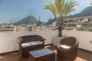 un balcón con 2 sillas y una palmera en ilive018-2 bedroom Penthouse on Copacabana BEACH, en Río de Janeiro