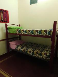 Etagenbett in einem kleinen Zimmer mit einer Bank in der Unterkunft HOSTEL JUJUY in San Salvador de Jujuy