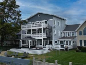 a large house with a porch and a deck at Perfect Group Getaway Sleeps 42 Guests in Blossvale