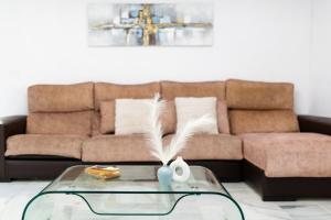 a living room with a couch and a glass table at Piso completo junto a parada de Metro in Maracena