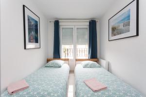 2 camas en una habitación con ventana en Le blanc mesnil 23 Abbé niort 1er ETG gauche en Le Blanc-Mesnil