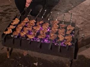 a bunch of food cooking on a grill at Xinaliq İzzet's Riverside Home Stay in Xınalıq