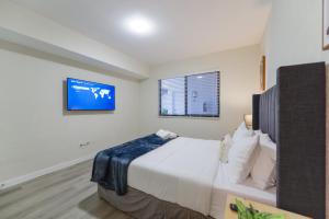 a bedroom with a large bed and a tv at Apartment in the Famous Calle Ocho in Miami in Miami